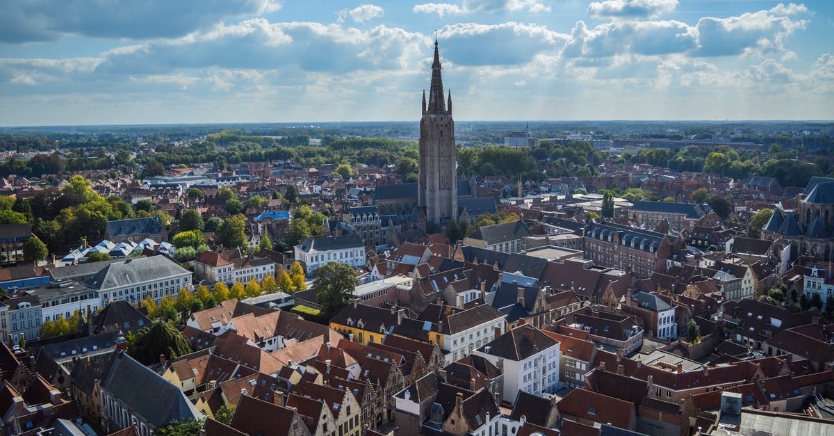 Schengen visa after a ban from Belgium - Spectacular drone view of Church of Our Lady and aged red roofed buildings in historical center of Bruges on sunny day Schengen visa after a ban from Belgium - Spectacular drone view of Church of Our Lady and aged red roofed buildings in historical center of Bruges on sunny day