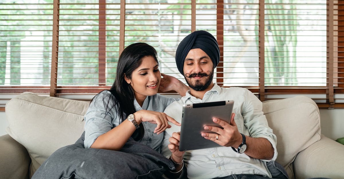Schengen visa application by an Indian studying in the UK - Content Indian woman and man in turban resting on cozy couch in living room and sharing tablet Schengen visa application by an Indian studying in the UK - Content Indian woman and man in turban resting on cozy couch in living room and sharing tablet