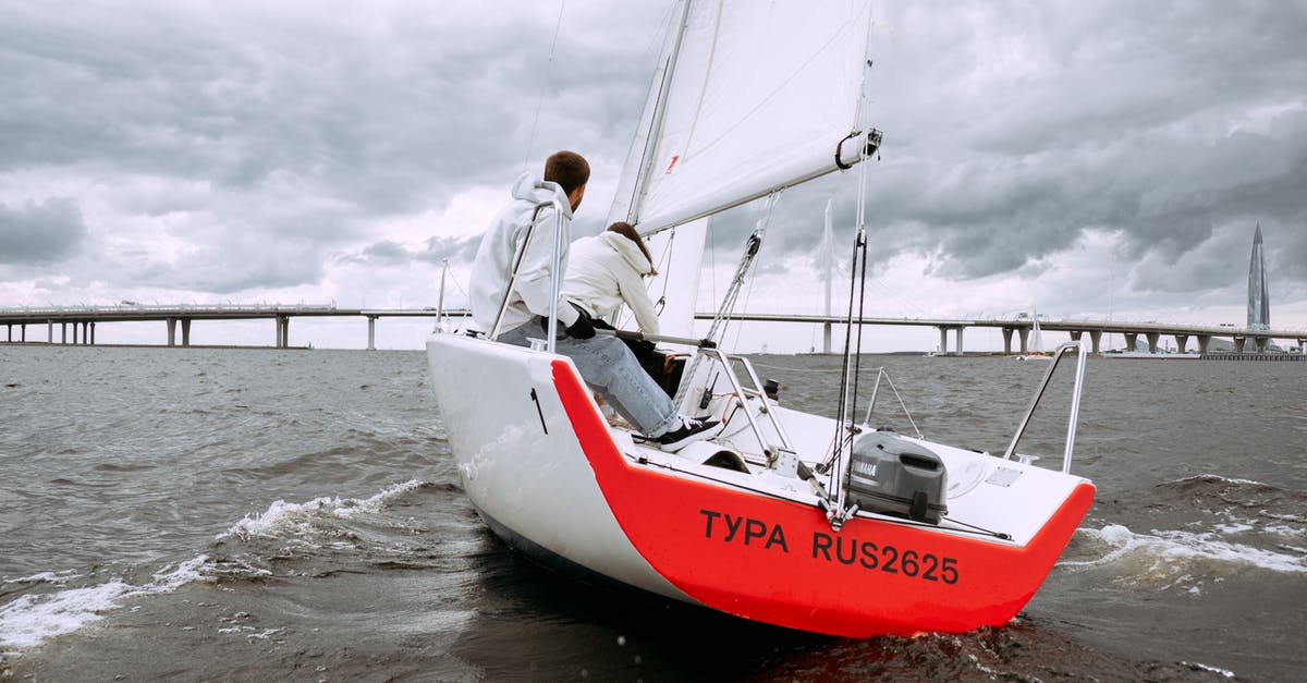 Schengen Visa at the border for spouse of ship's crew member - Man in White Shirt and Black Pants Riding on Red and White Boat