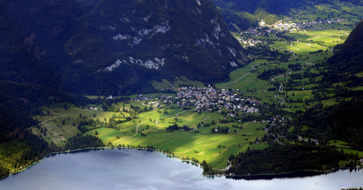Schengen visa denied by Slovenia despite being the main destination - Aerial view settlements on grassy peaceful valley surrounded with green hills and calm river on sunny day Schengen visa denied by Slovenia despite being the main destination - Aerial view settlements on grassy peaceful valley surrounded with green hills and calm river on sunny day