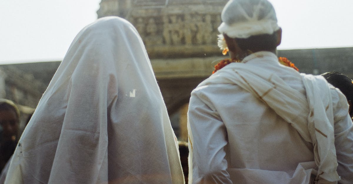 Schengen visa for Pakistani national married to British citizen wife - Unrecognizable couple in white traditional clothes during wedding ceremony