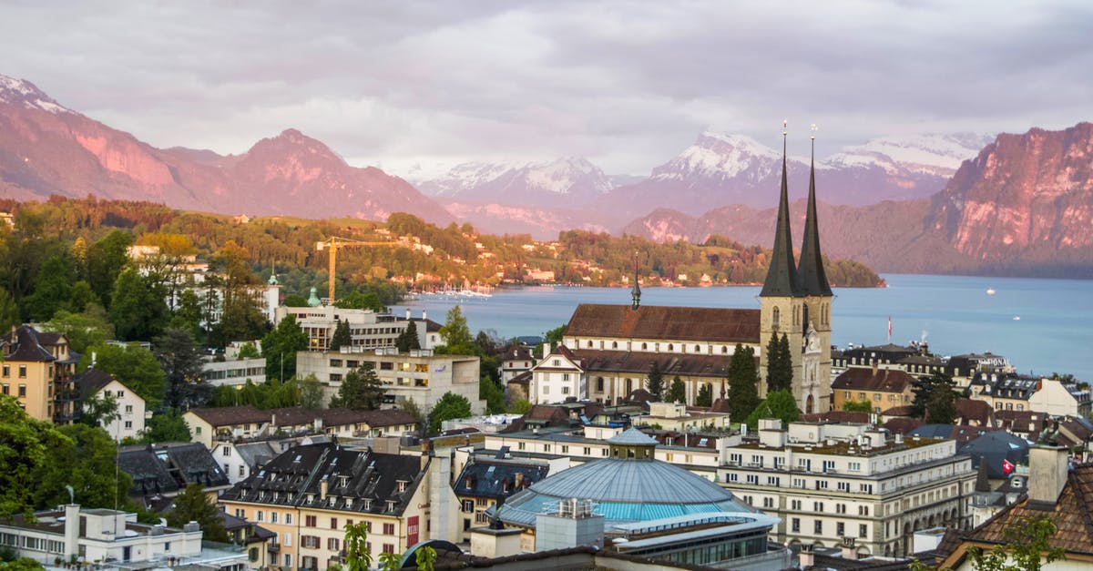 Schengen visa to travel from Germany to Switzerland - Majestic scenery of medieval city with Gothic cathedral in Alps on green seashore Schengen visa to travel from Germany to Switzerland - Majestic scenery of medieval city with Gothic cathedral in Alps on green seashore