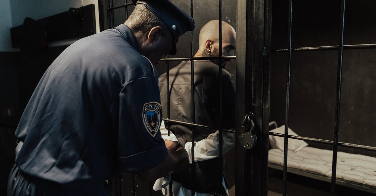 SCS Implant airport security fears [duplicate] - Man in Blue Security Uniform Standing beside Black Metal Bars