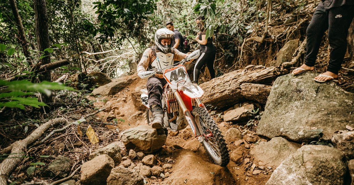 Search engine for bicycle rentals - Energetic male biker in helmet riding mountain motorbike on rough stony terrain in tropical forest Search engine for bicycle rentals - Energetic male biker in helmet riding mountain motorbike on rough stony terrain in tropical forest