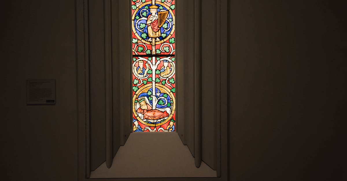 Searching for flights to "Anywhere" in narrow time frame - Narrow window with multicolored ornamental leaded glass in stucco frame located in dark grand cathedral Searching for flights to "Anywhere" in narrow time frame - Narrow window with multicolored ornamental leaded glass in stucco frame located in dark grand cathedral