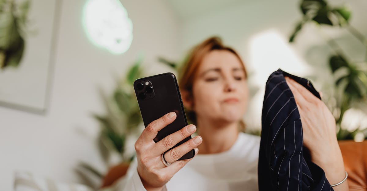 Searching for Lodging Along Interstates - Woman Using a Smartphone and Holding Fabric in the Other Hand Searching for Lodging Along Interstates - Woman Using a Smartphone and Holding Fabric in the Other HandÂ