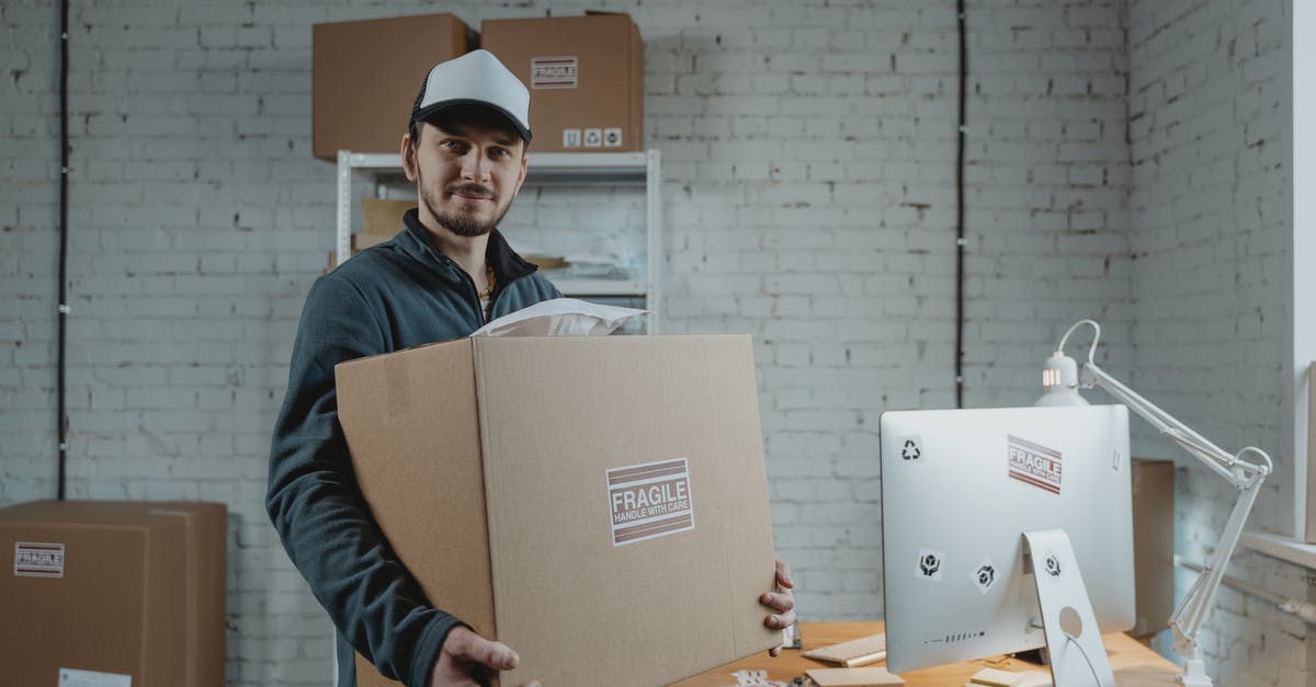 Shipping a computer from Europe to the U.S [duplicate] - Man in Jacket Holding Cardboard Box