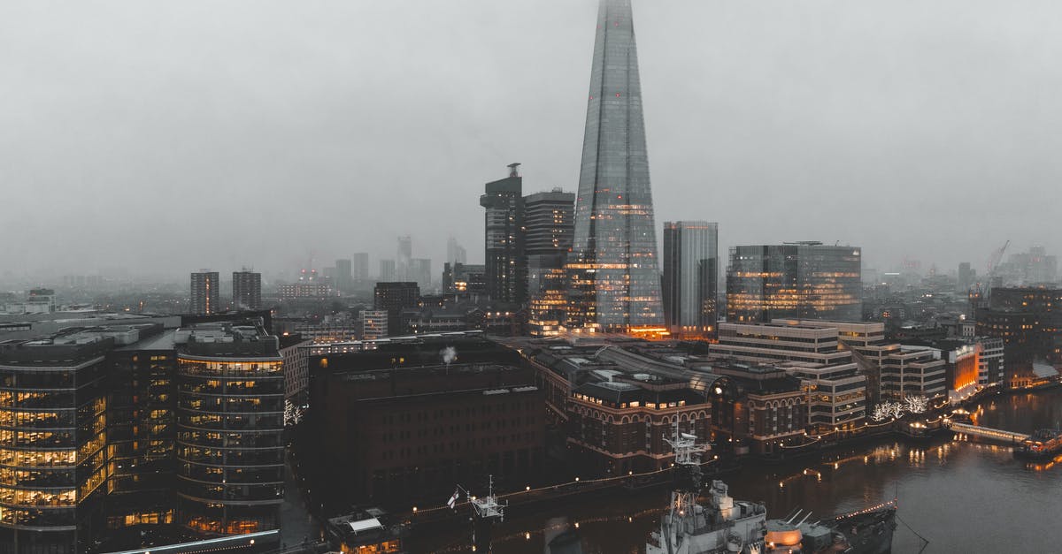 Shipping a UK Visa Application in the USA - Cityscape of river with ship near buildings in foggy weather Shipping a UK Visa Application in the USA - Cityscape of river with ship near buildings in foggy weather