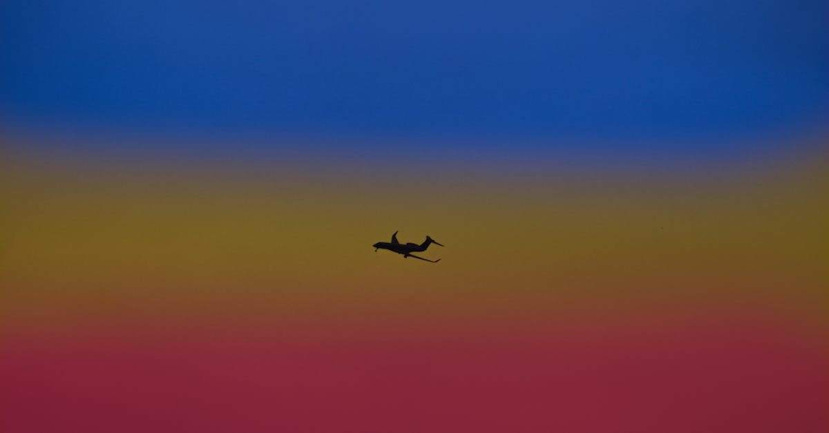 Shipping gear from Bangkok to Europe - Silhouette of airplane landing gear transporting people or goods soaring over bright colorful sky Shipping gear from Bangkok to Europe - Silhouette of airplane landing gear transporting people or goods soaring over bright colorful sky