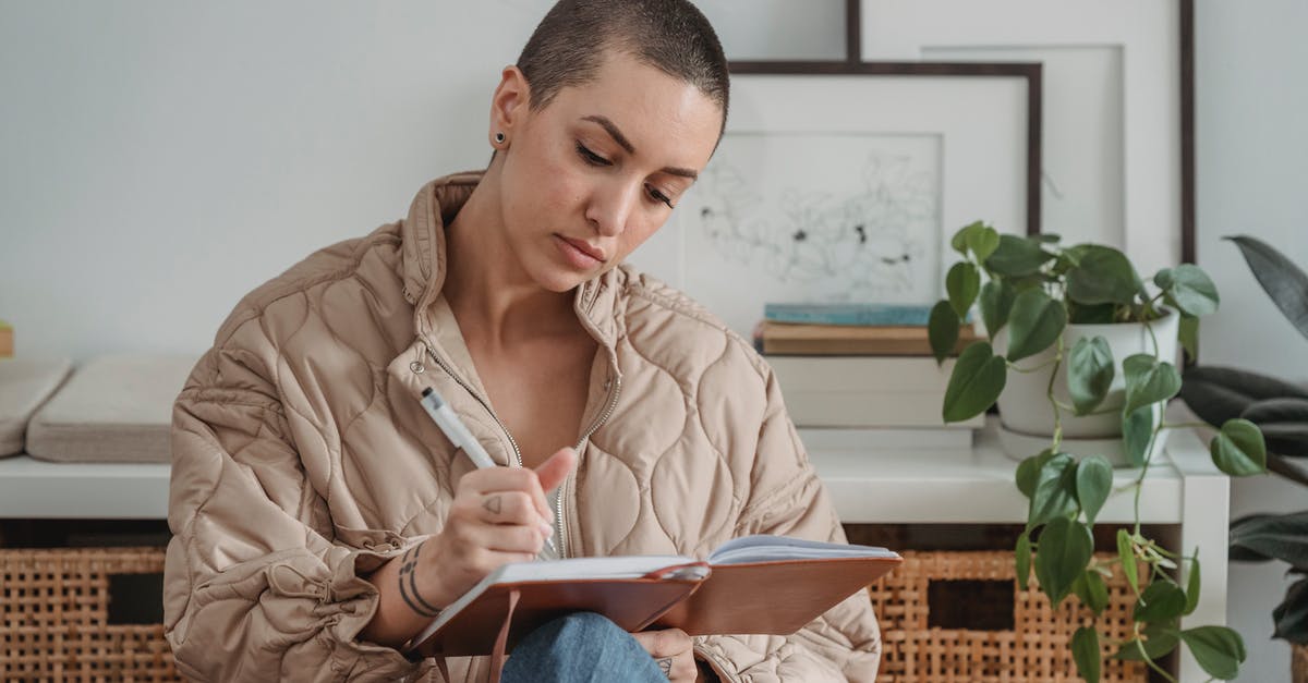 Short-term study visa UK - Pensive young female with short hairstyle writing in notebook while sitting in light living room Short-term study visa UK - Pensive young female with short hairstyle writing in notebook while sitting in light living room