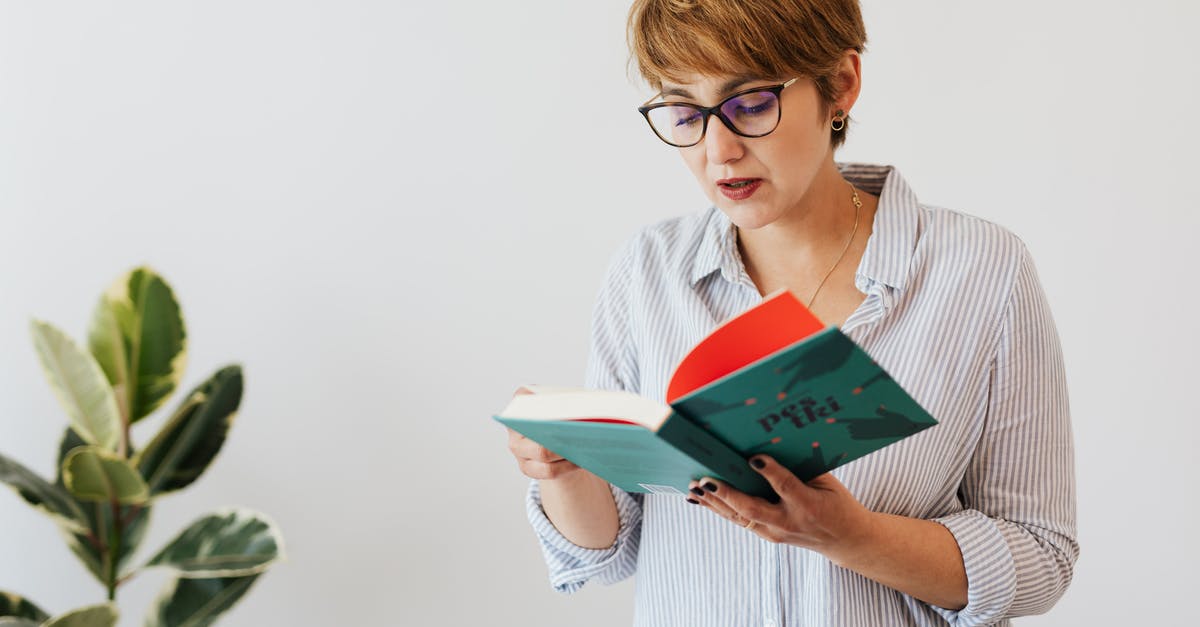 Short-term study visa UK - Smart woman in eyeglasses reading book Short-term study visa UK - Smart woman in eyeglasses reading book