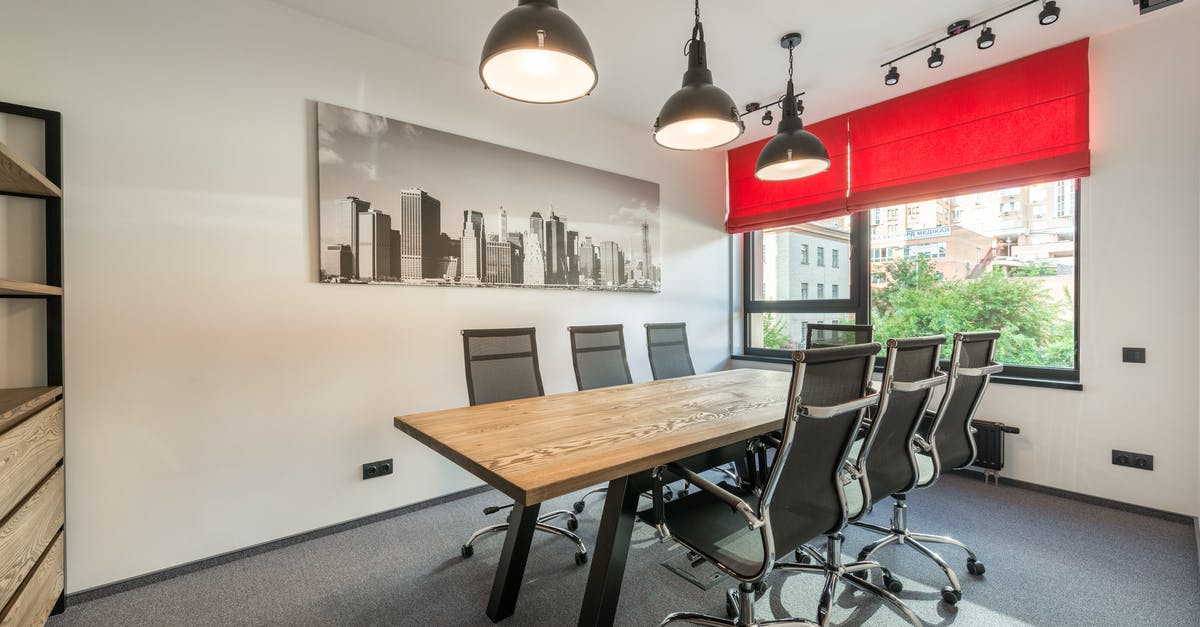 Should I apply for a UK visa to attend an onsite business meeting at a new job? - Wooden table with comfortable chairs in modern spacious conference hall with creative lamps and jalousie on windows Should I apply for a UK visa to attend an onsite business meeting at a new job? - Wooden table with comfortable chairs in modern spacious conference hall with creative lamps and jalousie on windows