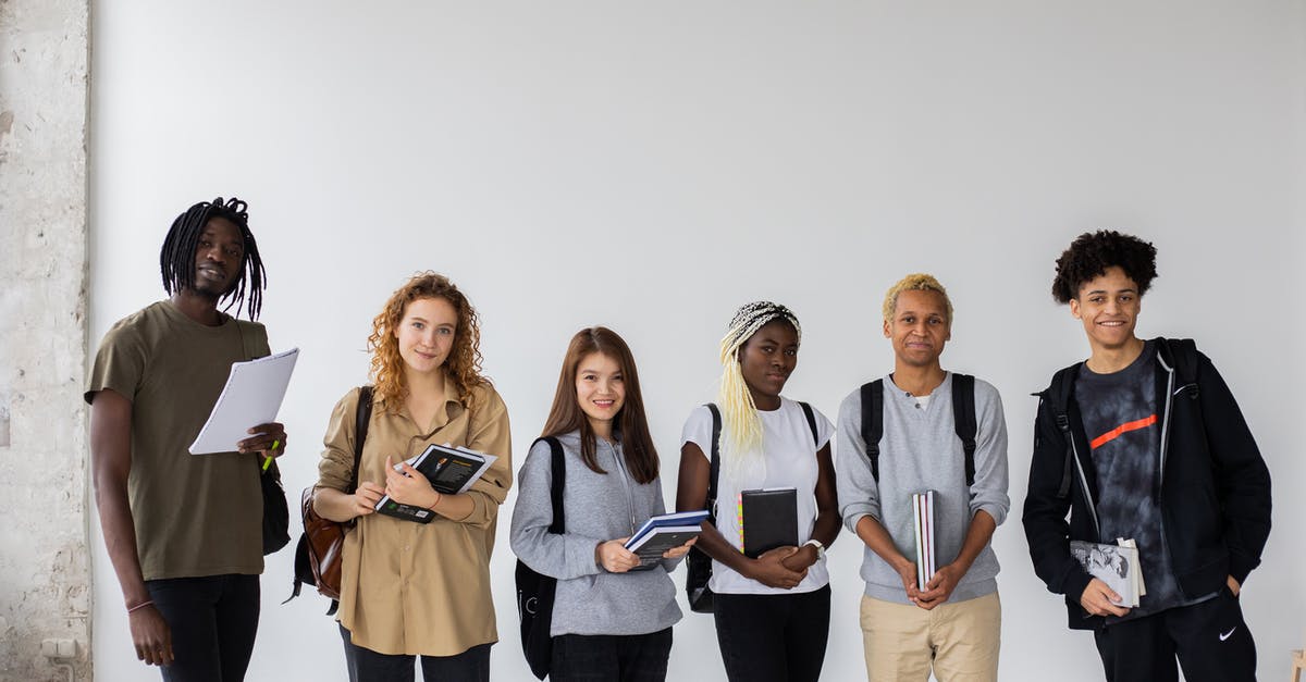 Should I book in advance cooking course in Thailand? - Group of diverse young multiracial classmates with notebooks and textbooks and backpacks smiling at camera