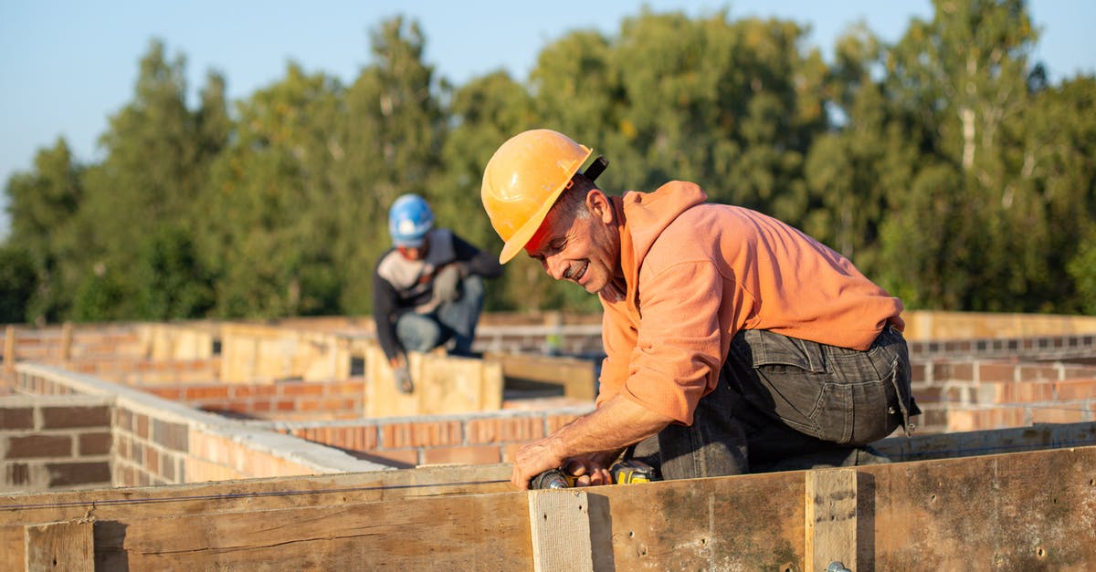 Should I leave the U.K. the day before my work visa expires? [closed] - Worker in Protective Helmet at Work on Construction Site