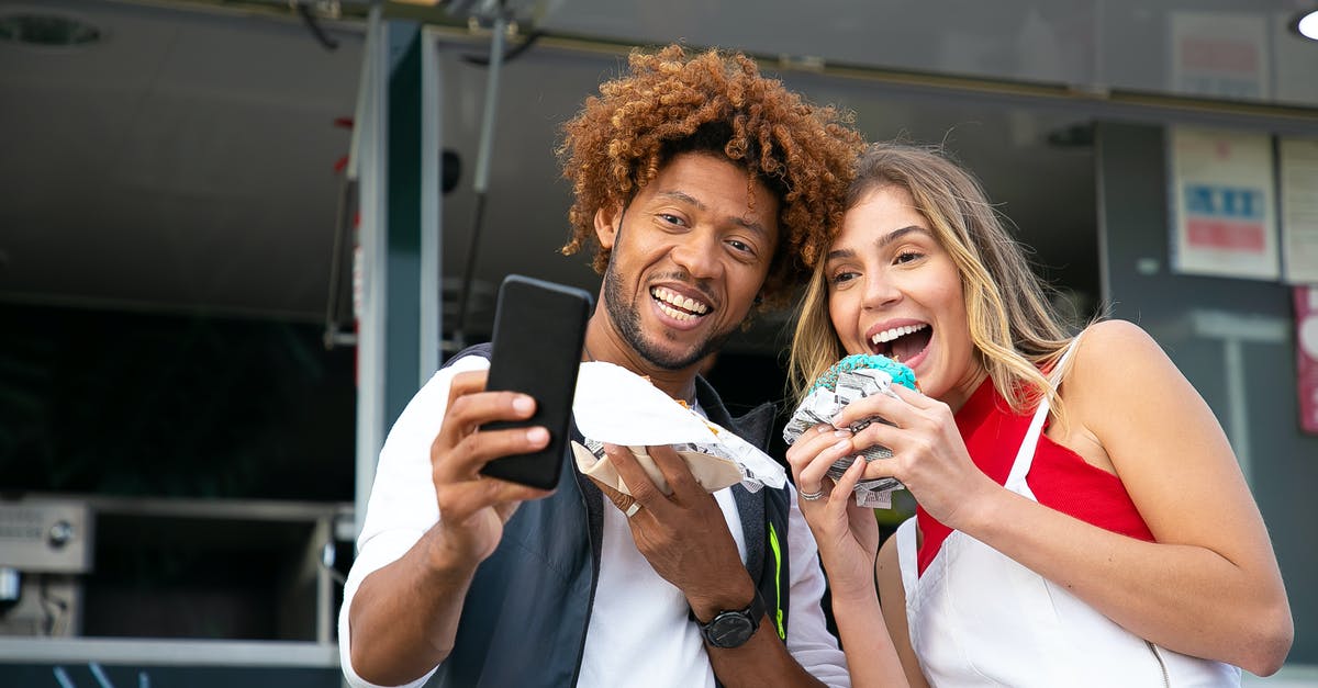 Shower at a truck stop for a couple travelling in car - Happy friends taking selfie with tasty burgers