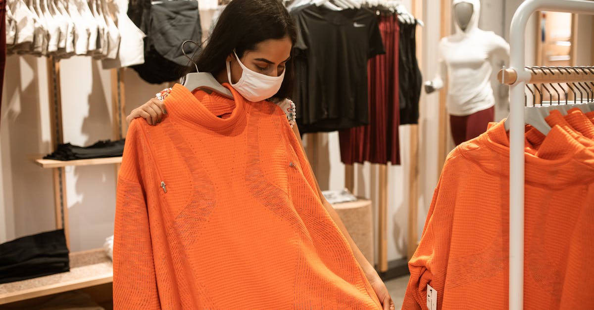 Simpler stop-over option - Woman Checking On An Orange Shirt Inside A Department Store Simpler stop-over option - Woman Checking On An Orange Shirt Inside A Department Store