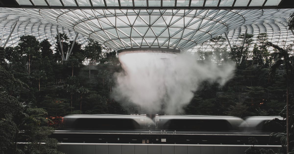 Singapore Airline-Transit for Level II Countries - Modern train riding under indoors waterfall in modern airport Singapore Airline-Transit for Level II Countries - Modern train riding under indoors waterfall in modern airport