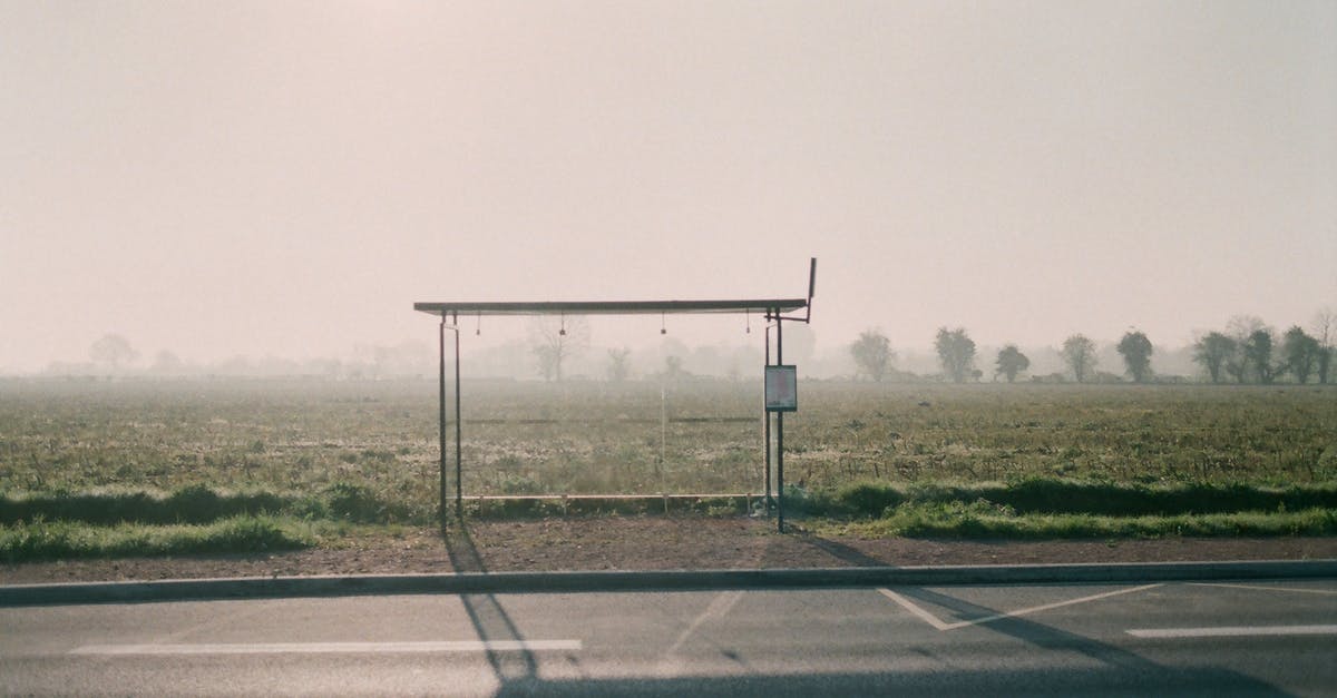 Single-entry Schengen visa on cruise that stops outside of the Schengen area - Empty bus stop placed near asphalt highway and grassy meadow against tall lush trees covered with mist in suburb area Single-entry Schengen visa on cruise that stops outside of the Schengen area - Empty bus stop placed near asphalt highway and grassy meadow against tall lush trees covered with mist in suburb area