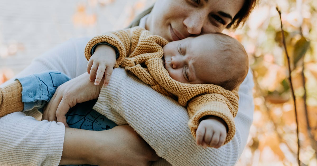 Sleeping aids for long flights [duplicate] - Woman Hugging her Sleeping Baby