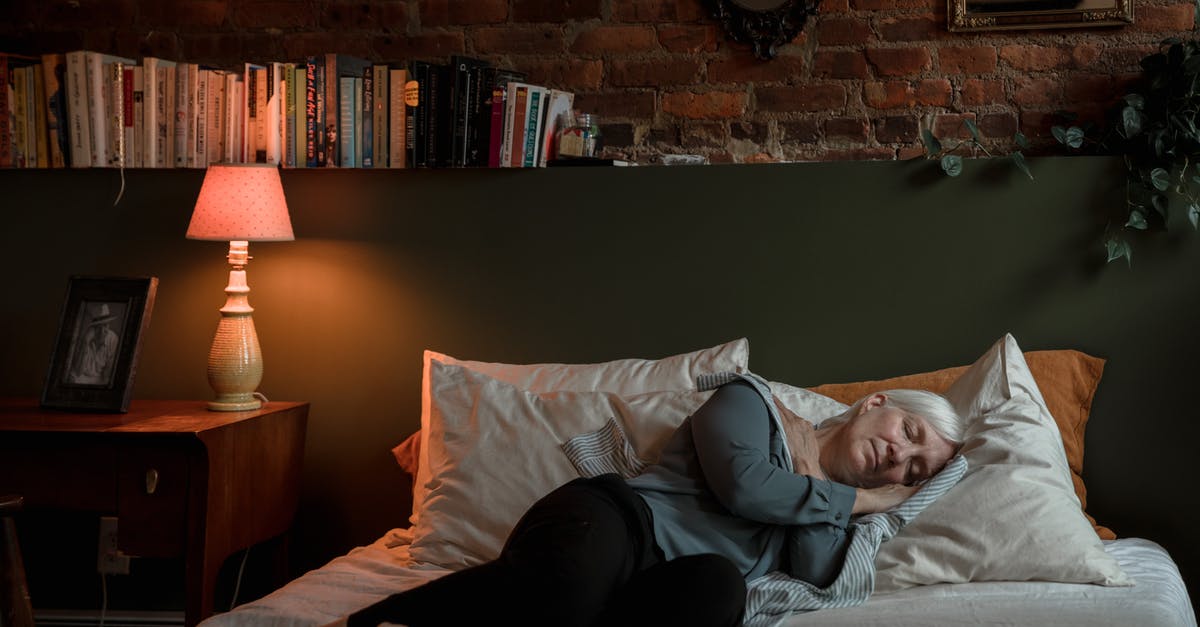 Sleeping at Toronto Pearson YYZ airside? - Woman in White Shirt Lying on Bed Sleeping at Toronto Pearson YYZ airside? - Woman in White Shirt Lying on Bed