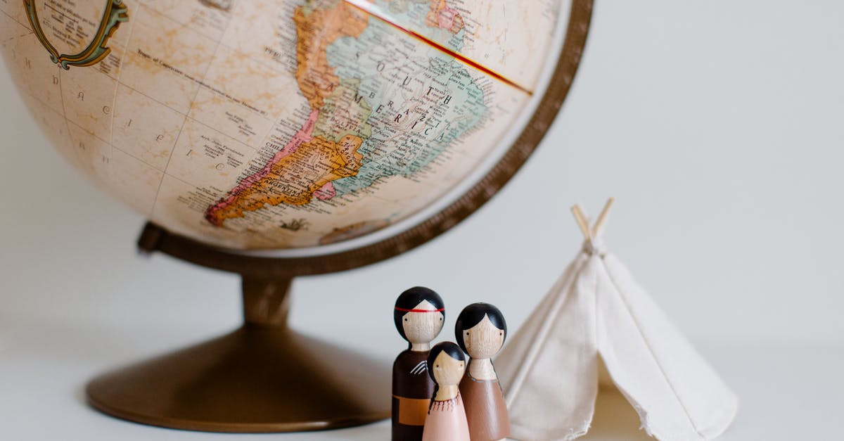 Slight smudge in Indian passport's officer stamp, can I travel with this? - From above of miniature toys tipi house and American Indian family placed near vintage globe against gray background at daytime