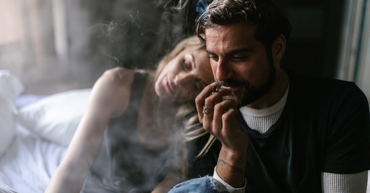 Smoking weed in Amsterdam as a tourist - Man in Blue Denim Jacket Smoking Cigarette Smoking weed in Amsterdam as a tourist - Man in Blue Denim Jacket Smoking Cigarette