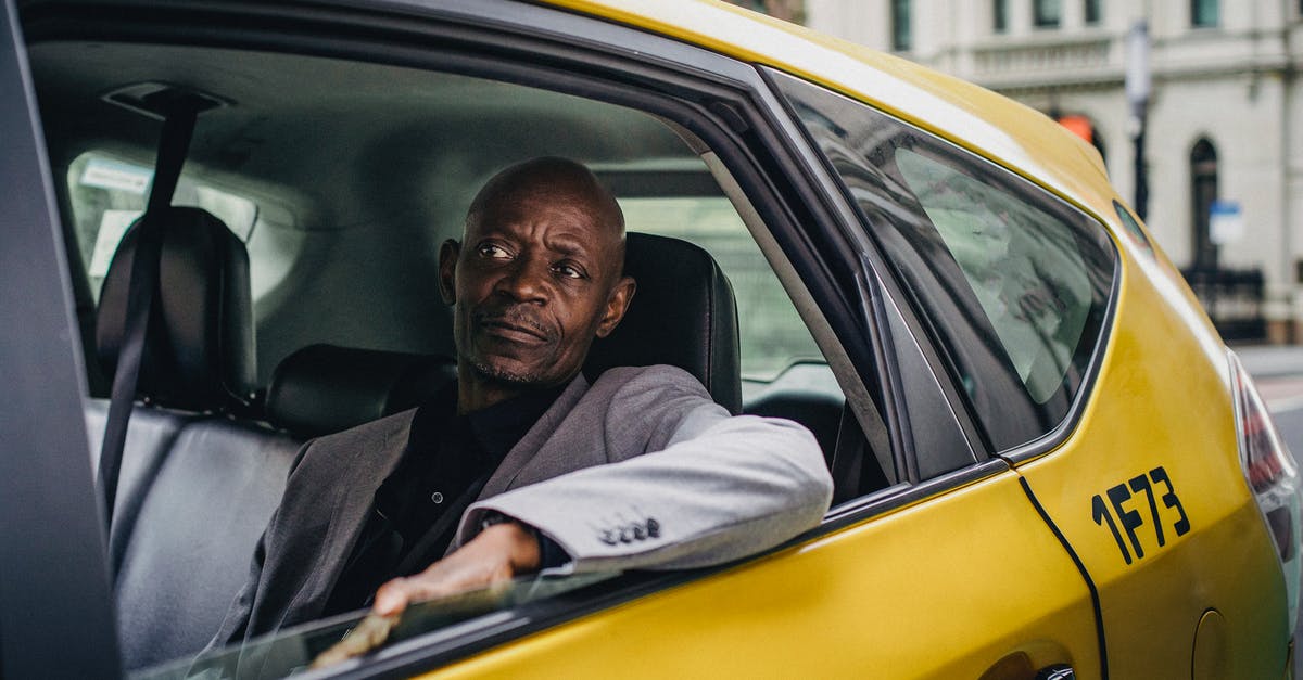 Sources of Authenticated Official information about carrying camping gas canisters on UK public transport - Middle aged African American male in business suit looking away while going by taxi