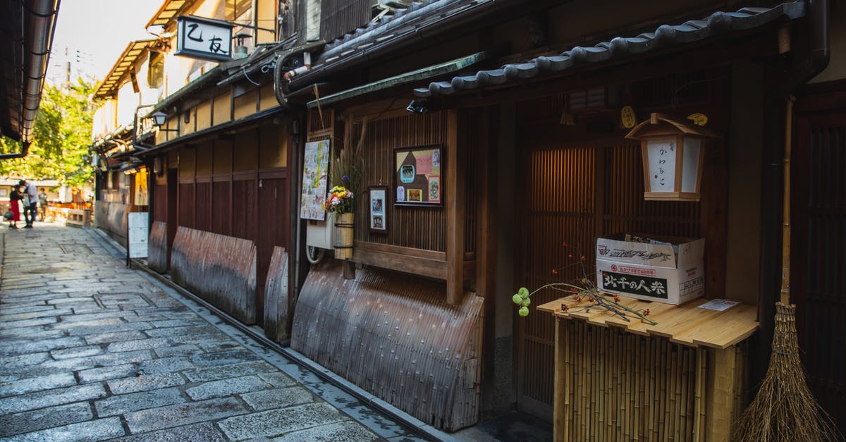 South East Asia - double entry without visa - Exterior of aged wooden houses with hieroglyphs located along narrow passage made of paving stone South East Asia - double entry without visa - Exterior of aged wooden houses with hieroglyphs located along narrow passage made of paving stone