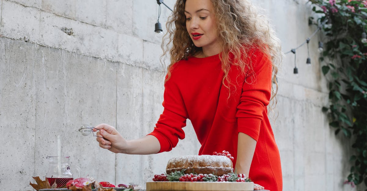 Special meals on long-haul flights - Elegant young female in bright red dress serving sweet delicious desserts on table in yard Special meals on long-haul flights - Elegant young female in bright red dress serving sweet delicious desserts on table in yard