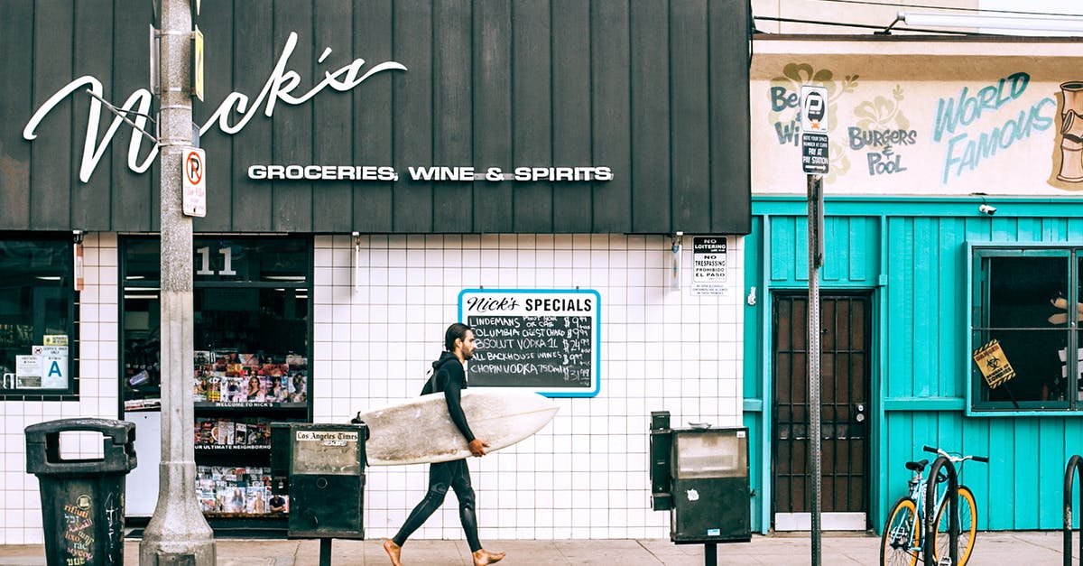 Spirit Airlines: Carry-on weight limit? - Man with surfboard walking along street Spirit Airlines: Carry-on weight limit? - Man with surfboard walking along street