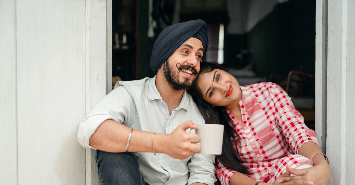 Spouse visa- Do I need a home surveyor? - Positive married couple relaxing on threshold of house Spouse visa- Do I need a home surveyor? - Positive married couple relaxing on threshold of house