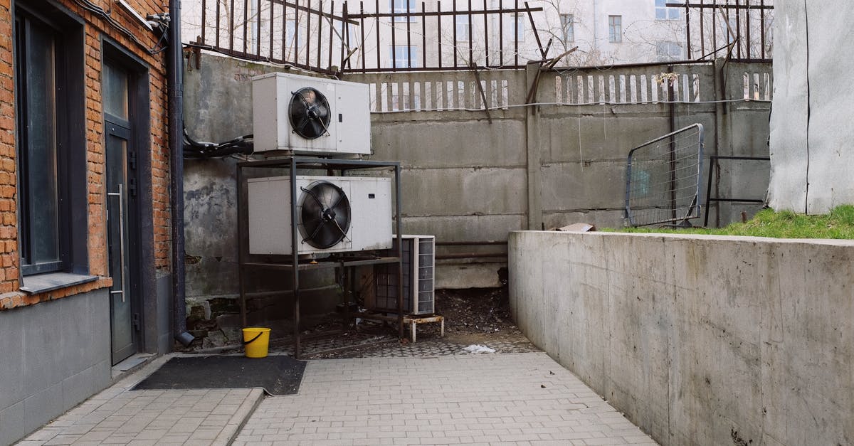 Stavropol City, surrounding area - Safety - Air conditioning system located outside concrete shabby fence with metal barrier near industrial building from bricks and glass door Stavropol City, surrounding area - Safety - Air conditioning system located outside concrete shabby fence with metal barrier near industrial building from bricks and glass door
