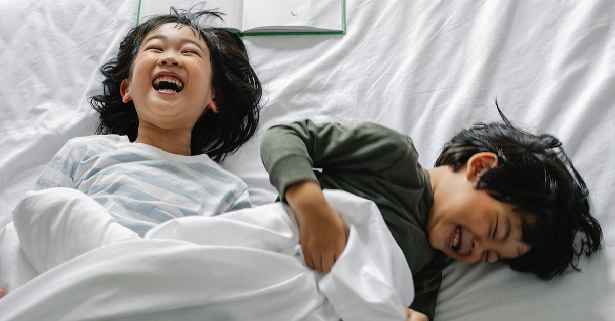 Stay Awake or Sleep to Minimize Jetlag? - Smiling Asian kids in bed Stay Awake or Sleep to Minimize Jetlag? - Smiling Asian kids in bed