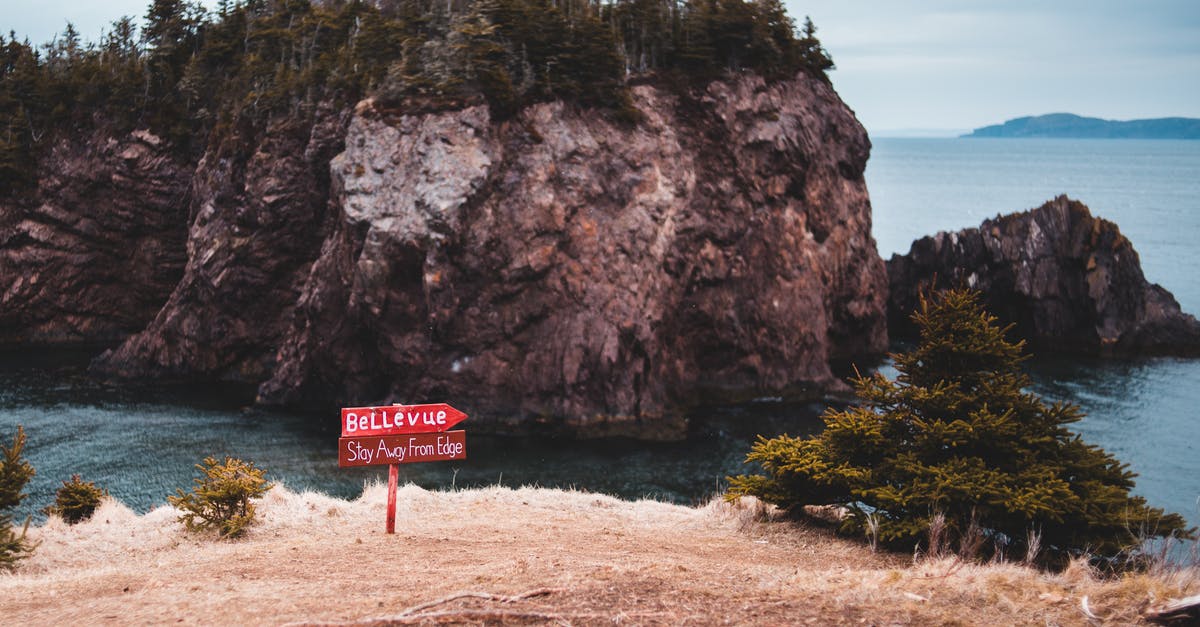 Staying in Canada beyond eTA and passport expiration [duplicate] - Caution signboard on edge of rocky cliff in front of wild island in sea