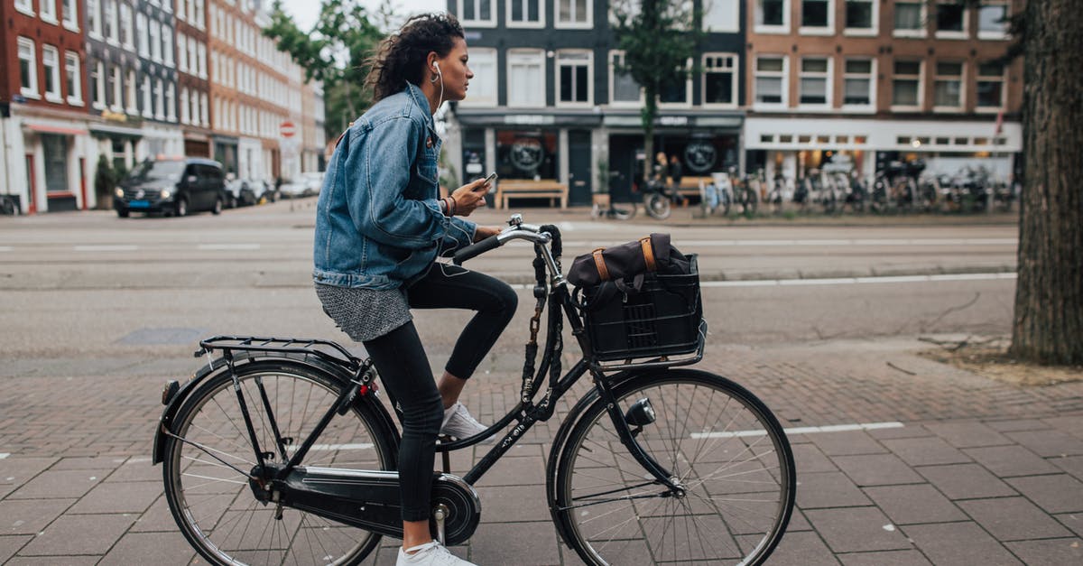 Staying near Rotterdam en-route to Cologne and visiting Amsterdam - Man in Blue Denim Jacket and Black Denim Jeans Riding Black Bicycle Staying near Rotterdam en-route to Cologne and visiting Amsterdam - Man in Blue Denim Jacket and Black Denim Jeans Riding Black Bicycle
