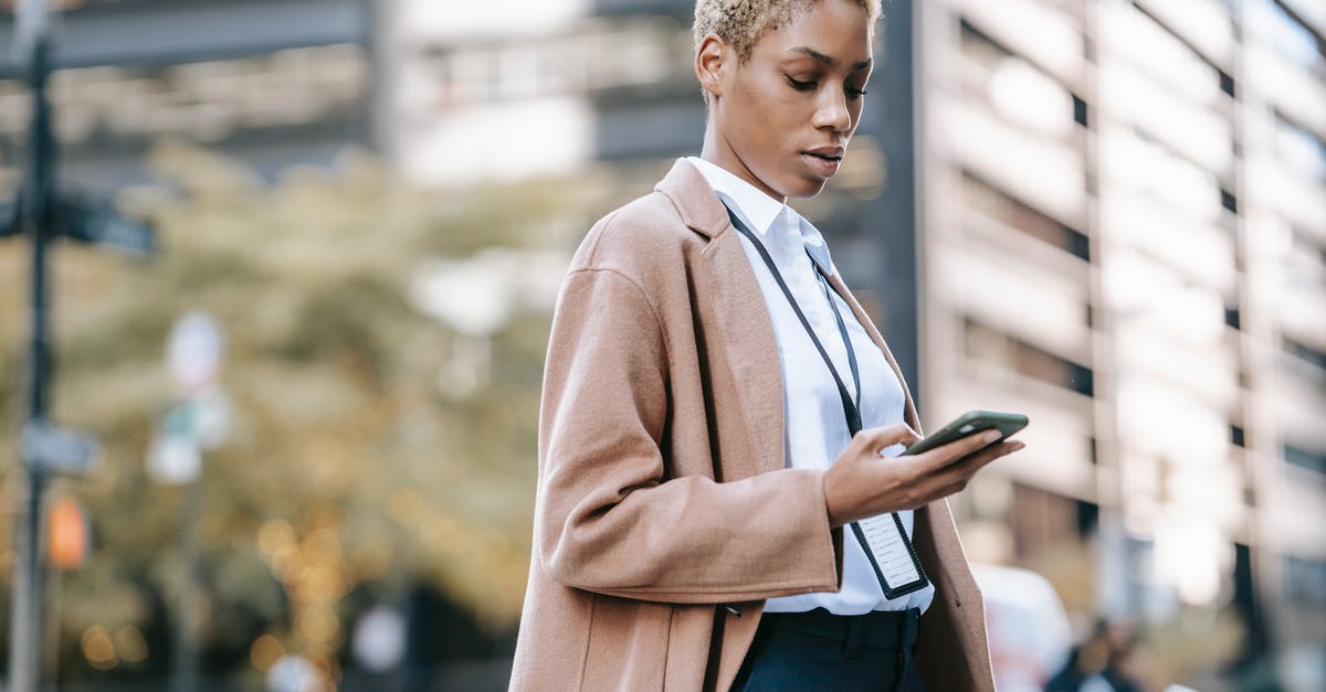 Step-down transformer that actually works? - Focused black businesswoman browsing smartphone on urban street Step-down transformer that actually works? - Focused black businesswoman browsing smartphone on urban street