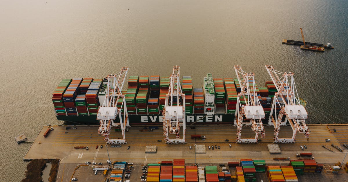 Stopping at an airport different from destination - From above of many cargo containers on ship moored on calm water of river in daytime Stopping at an airport different from destination - From above of many cargo containers on ship moored on calm water of river in daytime