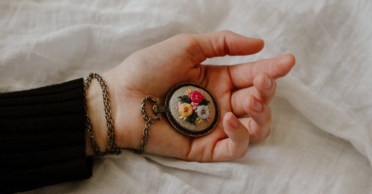 sturdy, metallic chess clock as carry-on baggage - Top view of crop anonymous female with vintage chain watch on hand on white fabric sturdy, metallic chess clock as carry-on baggage - Top view of crop anonymous female with vintage chain watch on hand on white fabric