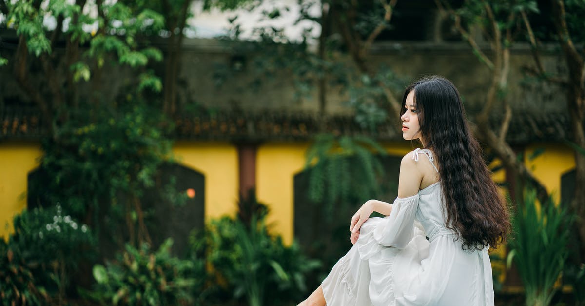 Swimming pool dressing code in Luxembourg - Pensive Asian woman on edge of pool