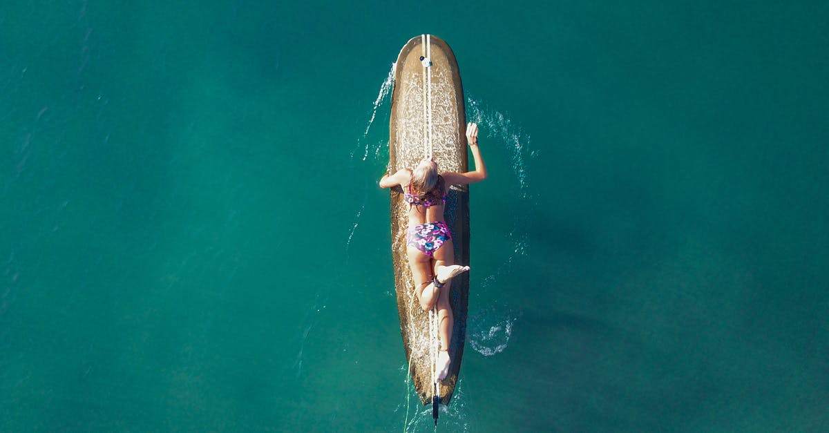 Swimwear customs on Côte d'Azur? - Female surfer floating on surfboard in sea Swimwear customs on Côte d'Azur? - Female surfer floating on surfboard in sea