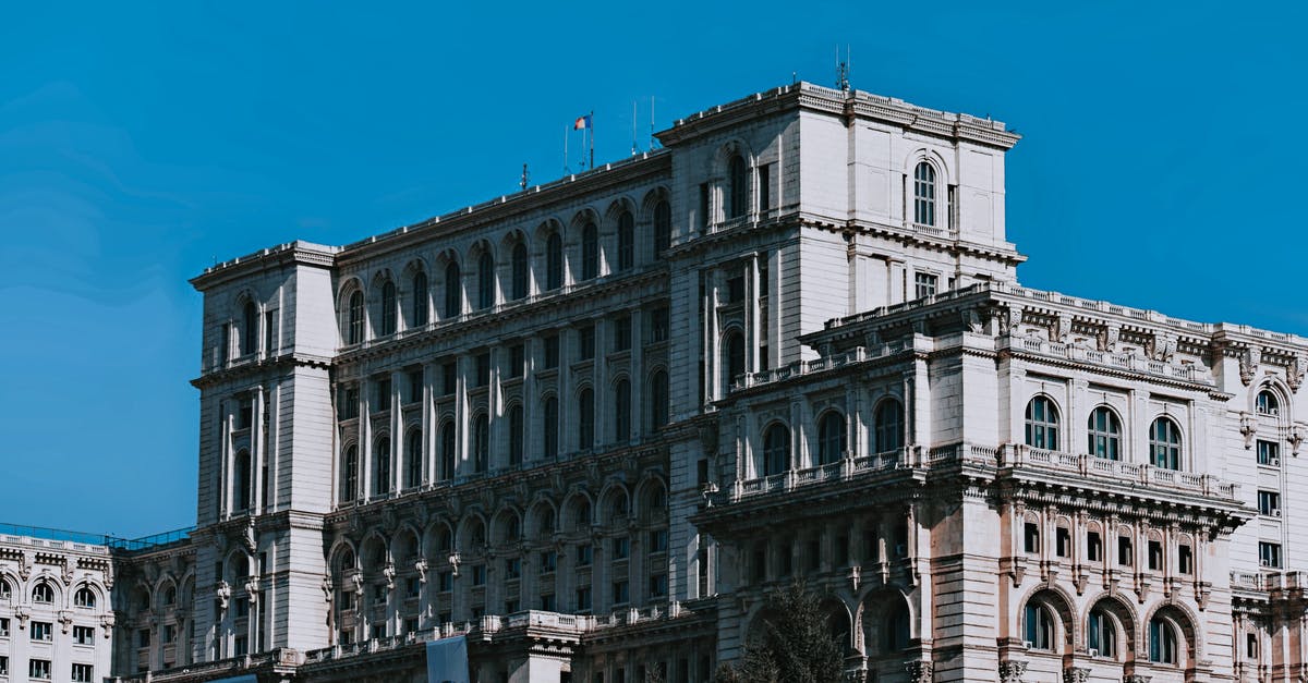 Syrian citizen with Schengen Residence Permit traveling to Romania - Exterior of aged Palace of the Parliament with arched windows located in Bucharest against cloudless blue sky on sunny day Syrian citizen with Schengen Residence Permit traveling to Romania - Exterior of aged Palace of the Parliament with arched windows located in Bucharest against cloudless blue sky on sunny day