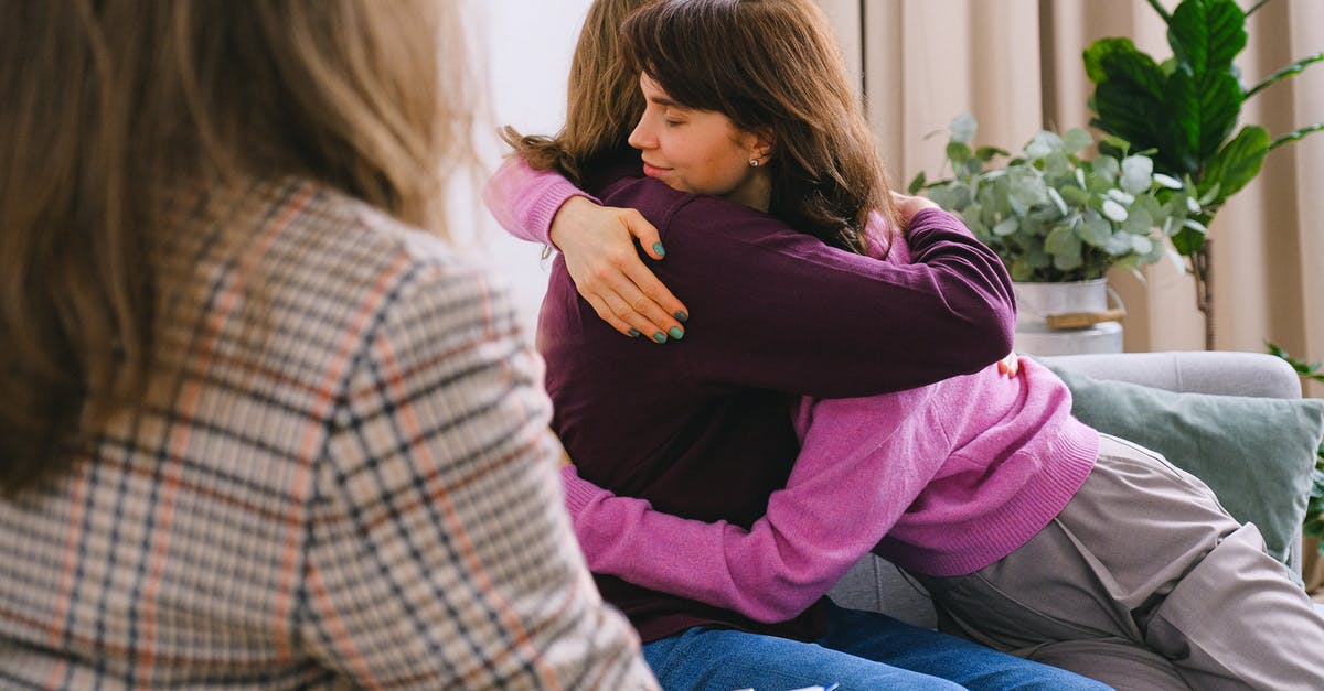Syrian refugee in Germany: Visit Ireland after being denied once [closed] - Side view of couple sitting on sofa and embracing during session with psychologist in light room in daytime
