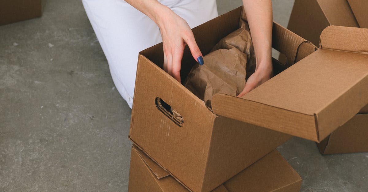 Take a new unpacked box of iPhone XS to India from US [duplicate] - Crop faceless woman packing belongings into cardboard box before relocation