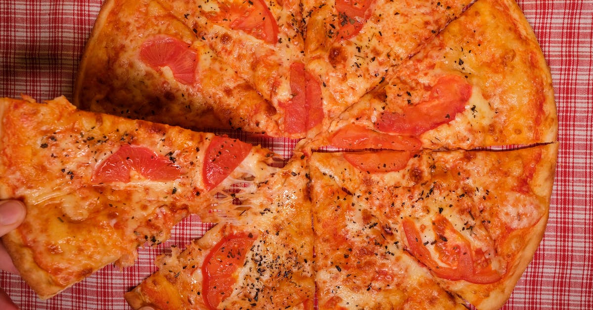 Take one more piece of luggage travelling from Dusseldorf to Yaounde Cameroon - Top view of crop anonymous person taking slice of yummy pizza with tomato and oregano placed on checkered tablecloth Take one more piece of luggage travelling from Dusseldorf to Yaounde Cameroon - Top view of crop anonymous person taking slice of yummy pizza with tomato and oregano placed on checkered tablecloth