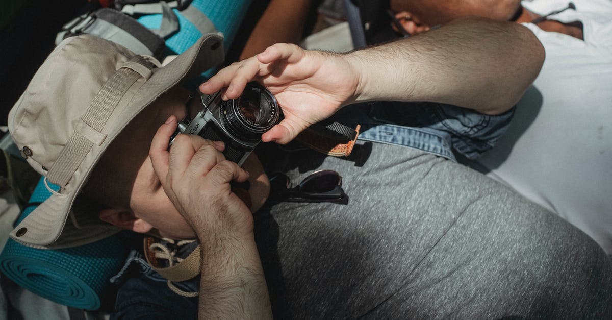 Taking a nap at Puy du Fou - Unrecognizable tourist taking photo on camera near sleeping black friend Taking a nap at Puy du Fou - Unrecognizable tourist taking photo on camera near sleeping black friend