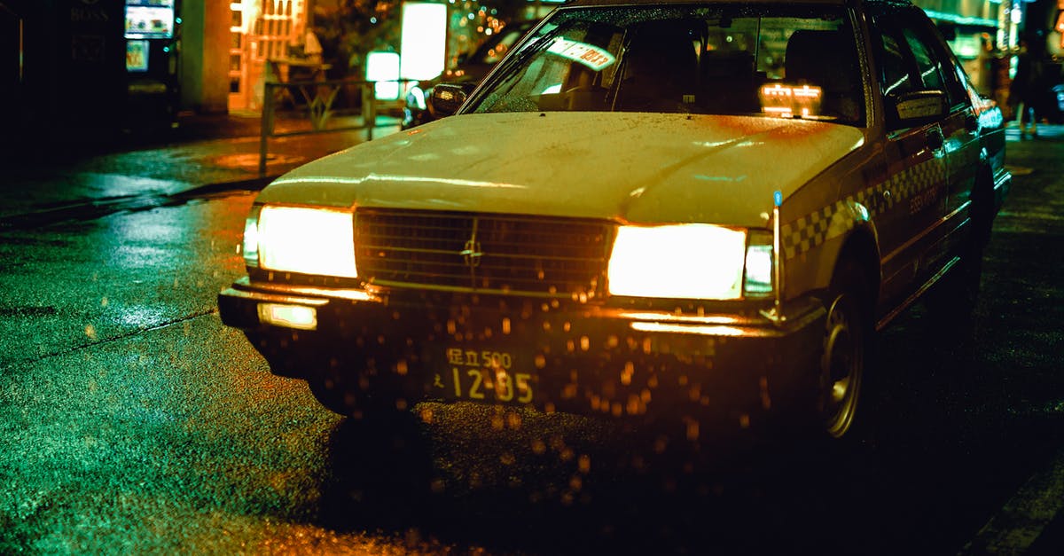 Taxis at Tokyo Haneda Airport - White Sedan during Nighttime Taxis at Tokyo Haneda Airport - White Sedan during Nighttime
