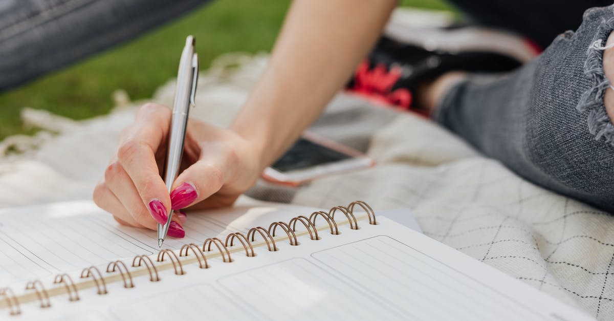 TGV timetables / schedules? - Crop anonymous lady in casual wear writing down plans for next day in organizer while sitting on blanket in quiet summer park TGV timetables / schedules? - Crop anonymous lady in casual wear writing down plans for next day in organizer while sitting on blanket in quiet summer park