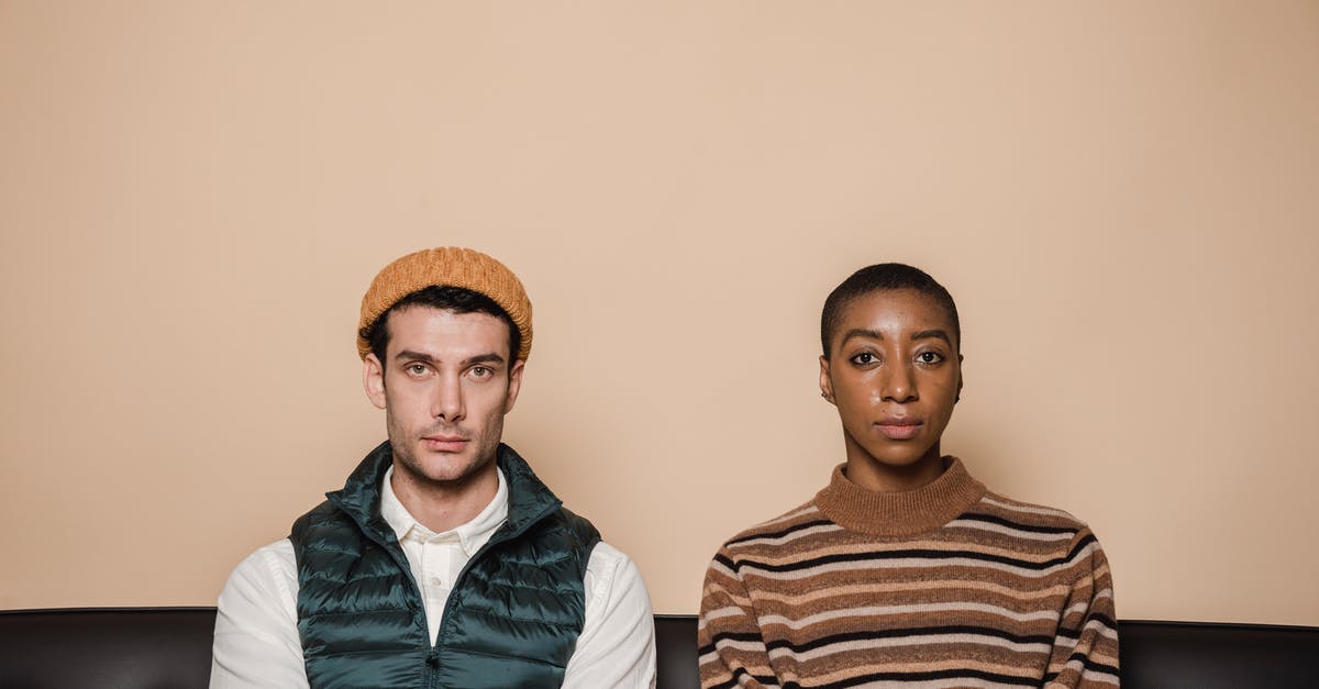 Thai girlfriend first visitor visa refused due to bad advice [duplicate] - Emotionless multiethnic couple sitting on couch against beige background and looking at camera