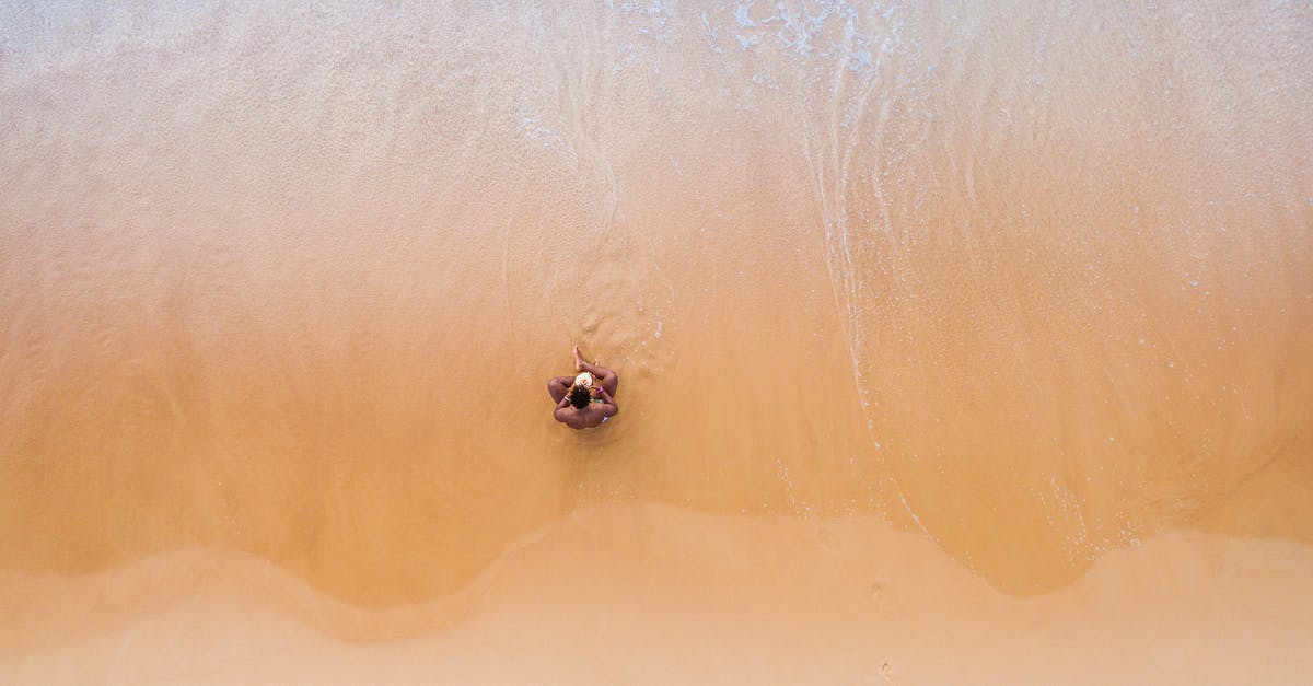 Thailand in October - Weather - Aerial Photography of Man Sitting on Beach Thailand in October - Weather - Aerial Photography of Man Sitting on Beach