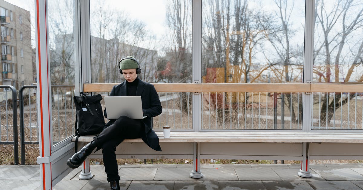 The difference between STOPS and EXTRA STOPS when using the ITA MATRIX - A Man Waiting at a Bus Stop while Using His Laptop
